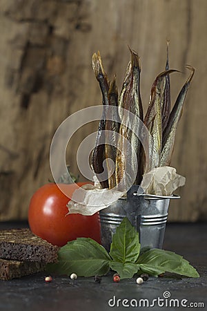 Capelin cold smoked fish in a decorative bucket on a black and o Stock Photo