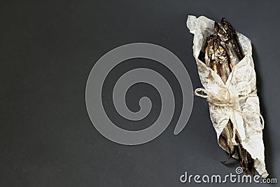 Capelin cold smoked fish wrapped in parchment and tied with a la Stock Photo