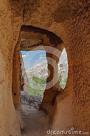 Cappadocia from inside cave house. Impressive fairy chimneys of sandstone in the canyon near Cavusin village, Cappadocia, Nevsehir Stock Photo