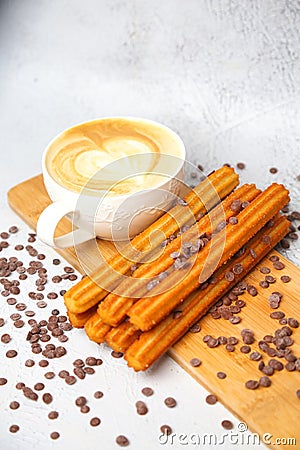 Cappuccino and Churro Sticks on a Cutting Board Stock Photo