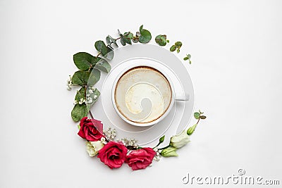 Cappuccino and flowers composition. White coffee cup with creamy foam, fresh flowers circle at white, top view. Hot Stock Photo