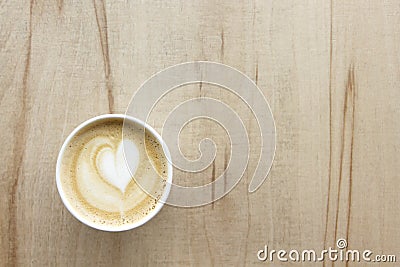 Cappuccino in paper take away cup on light wood table Stock Photo