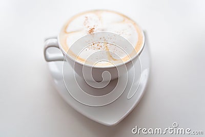 Cappuccino in a white cup on a white saucer. Stock Photo