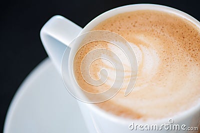 Cappuchino or latte coffe in a white cup on a dark background Stock Photo