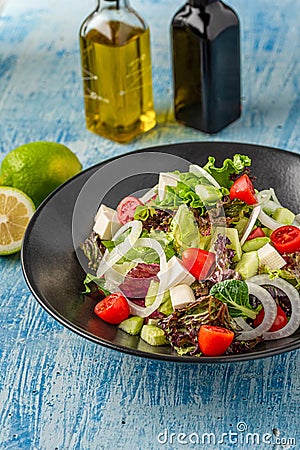 Caprese Italian or Mediterranean or Greek salad. Tomato, peynir, basil leaves and olive oil on wooden table Stock Photo