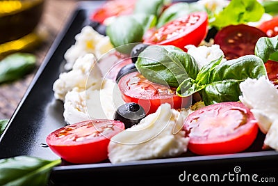 Caprese Salad.Mediterranean salad. Mozzarella cherry tomatoes basil and olive oil on old oak table. Italian cuisine Stock Photo