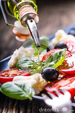 Caprese Salad.Mediterranean salad. Mozzarella cherry tomatoes basil and olive oil on old oak table. Italian cuisine Stock Photo