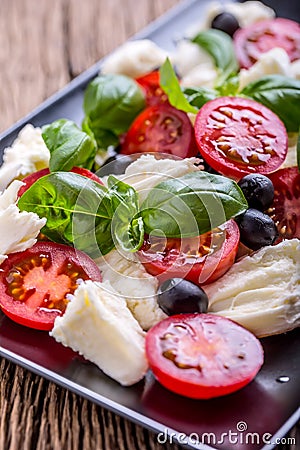 Caprese Salad.Mediterranean salad. Mozzarella cherry tomatoes basil and olive oil on old oak table. Italian cuisine Stock Photo