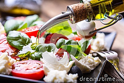 Caprese Salad.Mediterranean salad. Mozzarella cherry tomatoes basil and olive oil on old oak table. Italian cuisine Stock Photo