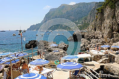 CAPRI, ITALY - JULY 4, 2018: rocky beach between Faraglioni cliffs of Capri, Italy Editorial Stock Photo