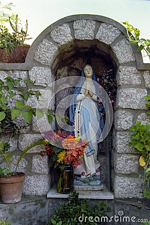 CAPRI, ITALY, 1983 - A small statue of the Madonna blesses passers-by along a street in Anacapri Editorial Stock Photo