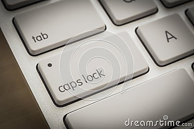 Caps lock button on white keyboard, dark filter Stock Photo