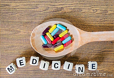 Capsules of Thai herbs medicine in the wooden spoon on table background, tropical herb ,organic plants for health care concept. Stock Photo