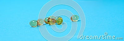 Capsules of vitamin D on a blue background, a long banner with space for text. Vitamins for people Stock Photo
