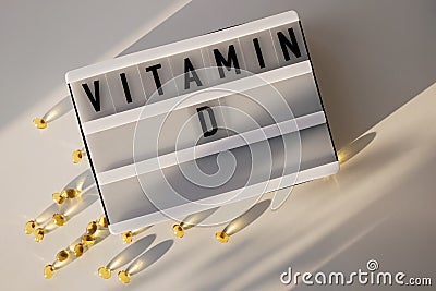 Capsules with vitamin D on the white table with natural sunlight. Stock Photo