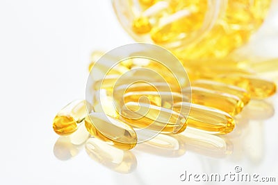 Capsules. Yellow pills isolated on white. Close up capsules with Vitamin D, E or Omega 3,6,9 fatty acids. Food supplement oil Stock Photo