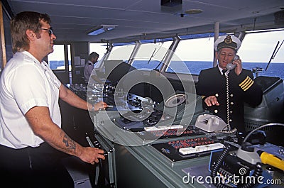 The captain of the ferry Bluenose speaking on the bridge phone while a crew member navigates the boat, Yarmouth, Nova Scotia Editorial Stock Photo