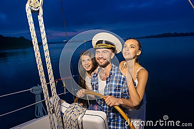Captain with girls on the yacht. Stock Photo