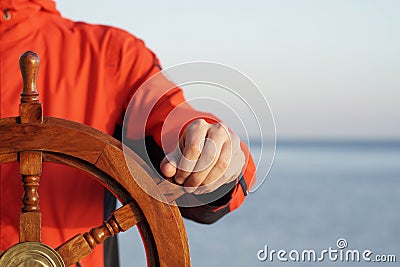 Captain holding hand on ship rudder. Stock Photo