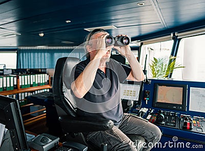 Captain of vessel or ship. He is looking through binoculars Stock Photo