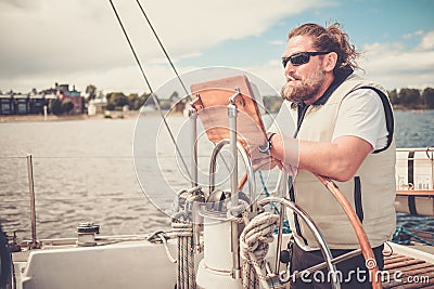 Captain on a yacht behind steering wheel Stock Photo