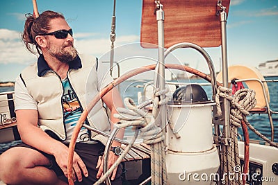 Captain on a yacht behind steering wheel Stock Photo