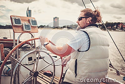 Captain on a yacht behind steering wheel Stock Photo