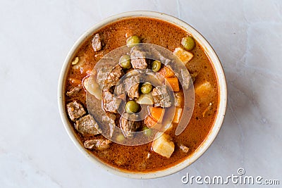 Tasty Hungarian Hot Goulash Soup Bograch or Gulas Lamb Meat Stew with Whole Grain Bread on Wooden Surface at Restaurant. Stock Photo