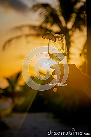 A captivating moment holding a cocktail glass in the Maldivian sunset Stock Photo