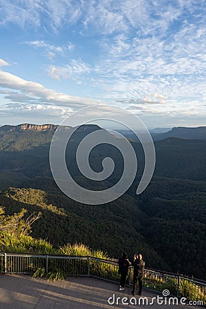 Captivating Sunset View: Tourists Overlook Canyon and Valley. At a lookout at the three sisters in the blue mountains Editorial Stock Photo