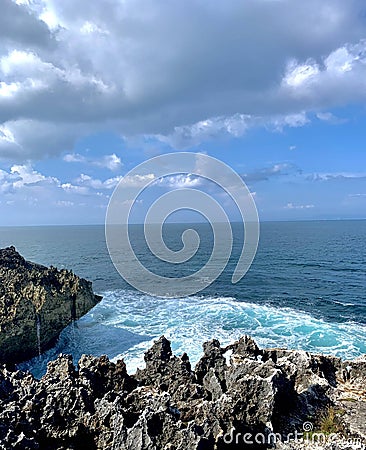 Capture of the light sea blue waves of the Indian Ocean crashing against the jagged limestone edges. Stock Photo