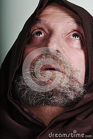 Capuchin monk with a beard illuminated by faith praying god Stock Photo