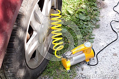 Car air compressor with yellow twisted hose Stock Photo