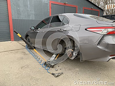 Car in a car service, repair of wheels. Concept: tire fitting, vulcanization, tire change. Car on a jack, changing wheels. Kiev Editorial Stock Photo