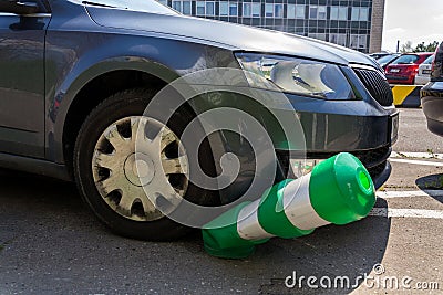 Car bending white and green safety traffic post with front bumper, wrong parking, car insurance, fine, penalty Stock Photo