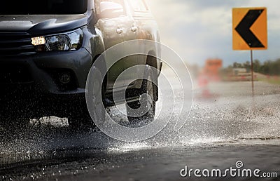 Car with big puddle of water spray from the wheels through flood water after hard rain. Stock Photo