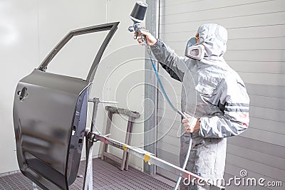 Car body painter spraying paint on bodywork parts Stock Photo