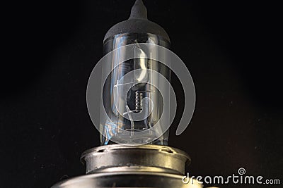 Car classic halogen bulb. Filament, glass and metal, high energy consumption. Black background. Close-up view. copy space. H4 Stock Photo