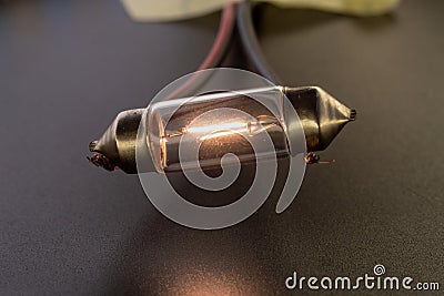 Car classic halogen bulb. Filament, glass and metal, high energy consumption. Black background. interior lighting. energized, Stock Photo