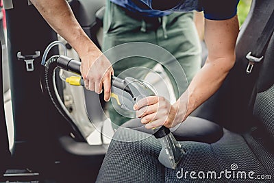 Car cleaning - male using professional steam vacuum for dirty car interior Stock Photo