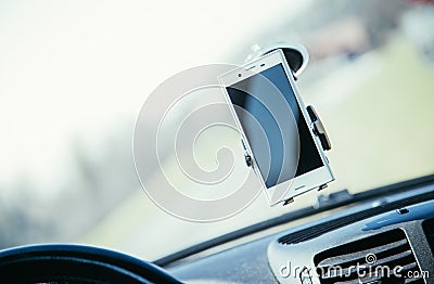 Car dashboard with smartphone used as navigation device, bright and sunny day Stock Photo