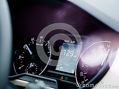 Car dashboard with speedometer showing 129 kilometres per hour Editorial Stock Photo