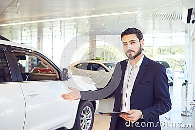 A car dealer shows a auto in a showroom. Auto business. Stock Photo