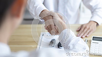 Car dealers or insurance dealers shake hands to congratulate the customers who have signed the car purchase contract Stock Photo