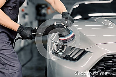 Car detailing and polishing concept. Hands of professional car service male worker, with orbital polisher, polishing Stock Photo