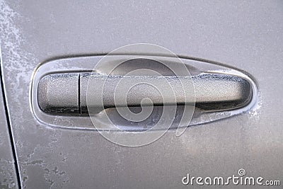 Car door handle covered in frost on early autumn morning. Dropping temperature approaching winter, ice crystals Stock Photo
