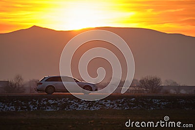 Car driving fast on intercity road at sunset. Highway traffic in evening Stock Photo