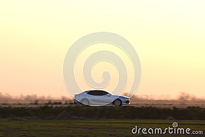 Car driving fast on intercity road at sunset. Highway traffic in evening Stock Photo