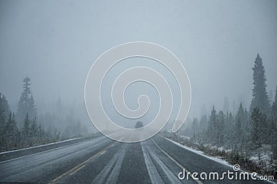 Car driving in heavy snow on highway in pine forest at Banff national park Stock Photo