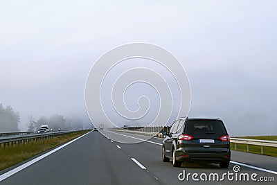 Car driving on highway in heavy fog. Traffic safety in heavy fog. Stock Photo